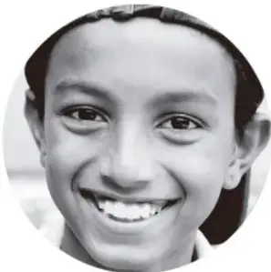 Fotografía de una niña sonriente con el cabello recogido.