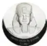 Fotografía del reverso de una medalla de plata con una cabeza olmeca; pie de foto: Medalla, Cabeza Olmeca, Ramsés II, Cruce de Caminos, México, 1992, plata, diámetro 65 mm, Casa de Moneda de México, Museo Numismático Nacional.