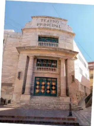Fotografía del Teatro Principal, edificio antiguo de piedra con columnas y puerta ornamentada.