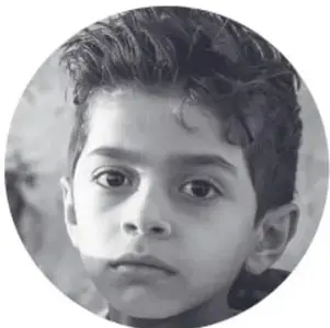 Fotografía en blanco y negro, dentro de un círculo, del rostro de un niño que mira con expresión seria.