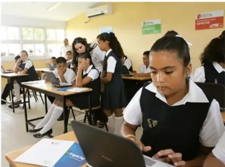Foto de estudiantes en un aula de Telesecundaria trabajando con laptops, ilustrando el nivel educativo como parámetro de calidad de vida.