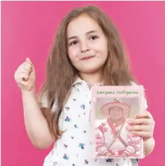Fotografía de una niña sosteniendo una libreta con la portada "Lenguas indígenas".