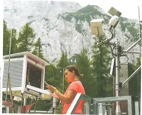 Persona observando una estación meteorológica con varios instrumentos para medir fenómenos atmosféricos.