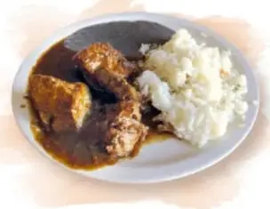 Plato de cochito (carne de cerdo) acompañado de arroz.