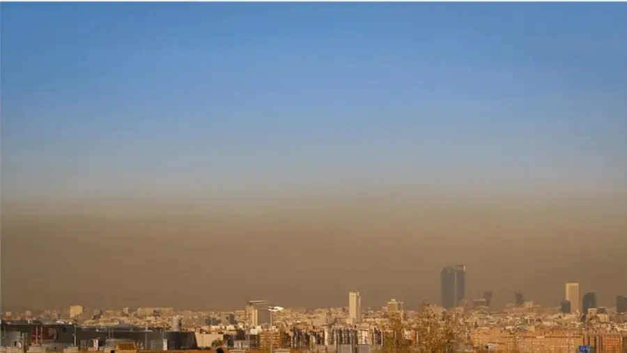 Fotografía de una ciudad con smog: capa de aire contaminado de color anaranjado sobre el horizonte urbano, ilustrando la contaminación atmosférica.