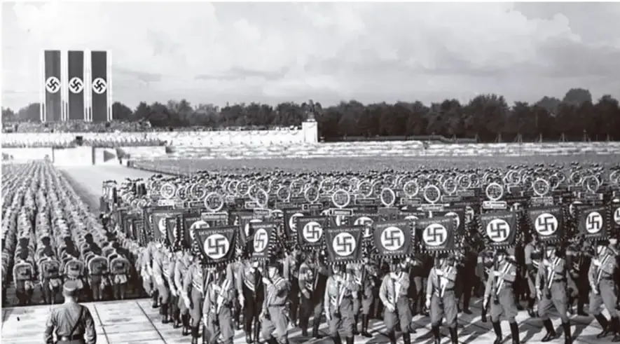 Desfile militar nazi en Núremberg con formaciones y banderas con esvásticas.