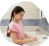 Fotografía de una niña lavándose las manos en un lavabo, con el pie de foto 'Hábito de higiene'.