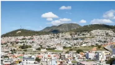 Vista histórica en sepia de la ciudad ubicada en el fondo de un valle rodeado de cerros.