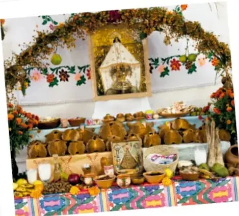 Altar de muertos con ofrendas, flores y comida tradicional.