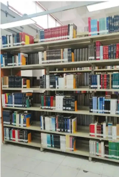 Fotografía de estantes de biblioteca llenos de libros ordenados por colores.