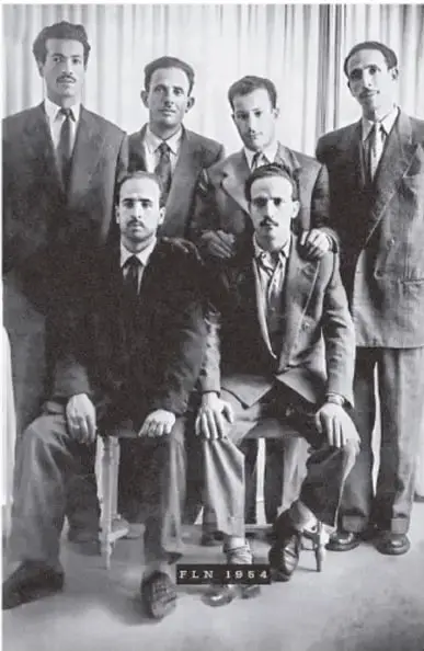 Fotografía en blanco y negro de seis hombres del FLN en 1954, algunos de pie y otros sentados, con traje y corbata.
