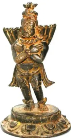 Escultura metálica (bronce dorado) de una deidad india de múltiples brazos sobre una peana circular, relacionada con la iconografía védica/hindú.