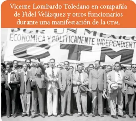 Fotografía en blanco y negro de Miguel Henríquez Guzmán saludando con el brazo en alto durante un acto político.