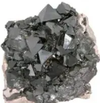 Muestra un trozo de magnetita, mineral negro brillante de óxido de hierro.