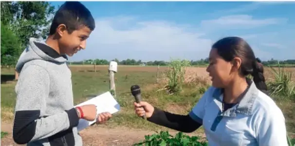Fotografía de un estudiante entrevistando a una persona con micrófono en un entorno rural; pie de foto: Jesús Eduardo Arteaga Flores, TAMAULIPAS.