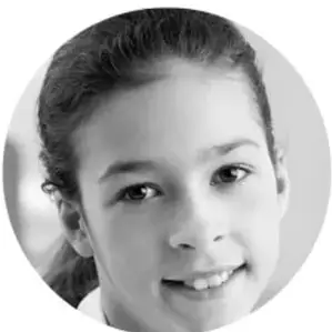 Fotografía circular en blanco y negro de una niña sonriente, como ejemplo de estudiante participante.