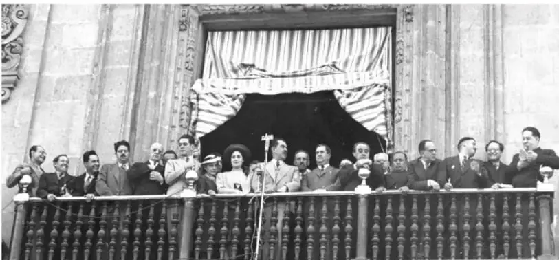 Fotografía histórica en blanco y negro: grupo de personas (funcionarios y ciudadanos) sobre un balcón o tribuna con micrófono, probablemente el anuncio de la Expropiación petrolera por Lázaro Cárdenas.