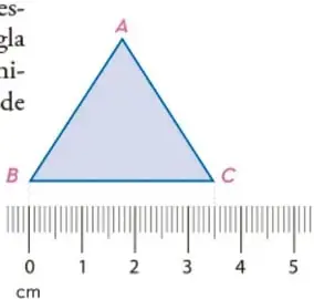 Triángulo de vértices A, B y C con una regla graduada en centímetros colocada bajo el lado BC. La regla muestra marcas del 0 al 5 cm. El lado BC mide 3.5 cm.