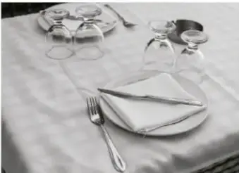 Mesa con mantel, platos, vasos y cubiertos.