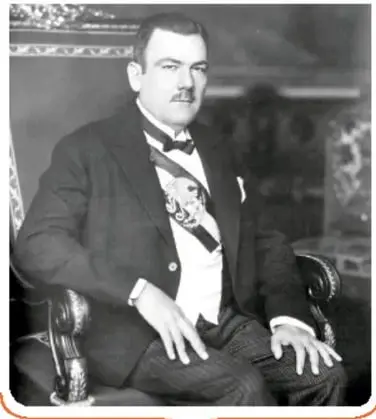 Retrato de Plutarco Elías Calles sentado, con traje y banda presidencial.