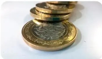 Fotografía de monedas de oro apiladas, que ilustra las aplicaciones de los decimales en la conversión de monedas.