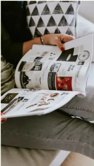Persona sosteniendo un periódico con el titular 'EVERY STUDENT'.