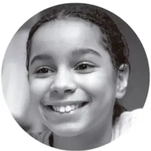 Fotografía en blanco y negro de una niña sonriente, con cabello recogido, mirando a la cámara.