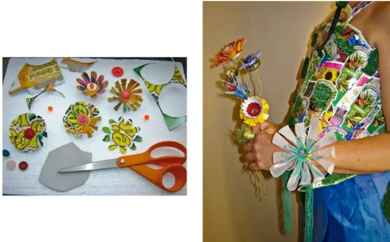 Fotografía de una mesa de trabajo con flores artesanales hechas con tapas y materiales reciclados, tijeras y botones.
