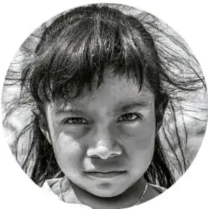 Fotografía en blanco y negro de una niña de primaria con cabello recogido, mirando de frente con expresión serena.