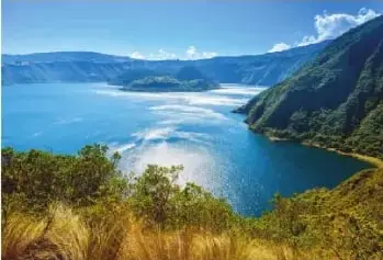 Fotografía de la laguna de Cuicocha, en la provincia de Imbabura, rodeada de montañas.