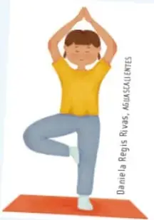 Niño con camiseta amarilla en postura de equilibrio sobre tapete rojo.