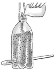 Botella plástica con tapa perforada y pajita, con agua y burbujas; una mano vierte agua desde un vaso. Se observa una cuchara al costado.
