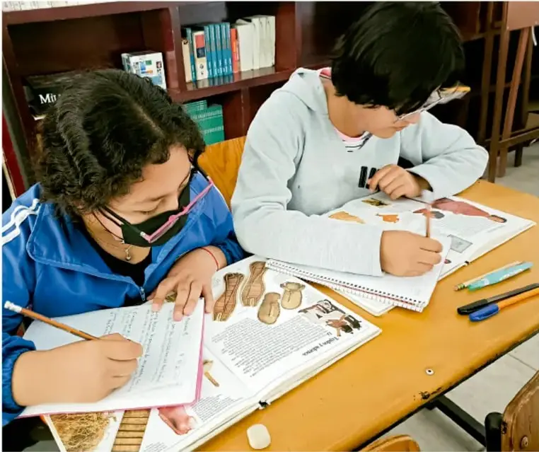 Fotografía de dos estudiantes en el aula trabajando con libros y cuadernos; crédito: Luis Eduardo García Medel, Tlaxcala.