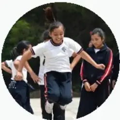 Niñas corriendo y jugando en un parque durante la actividad física.