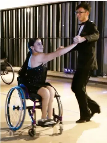 Dos personas practicando danza; una de ellas en silla de ruedas, simbolizando inclusión en la actividad física.