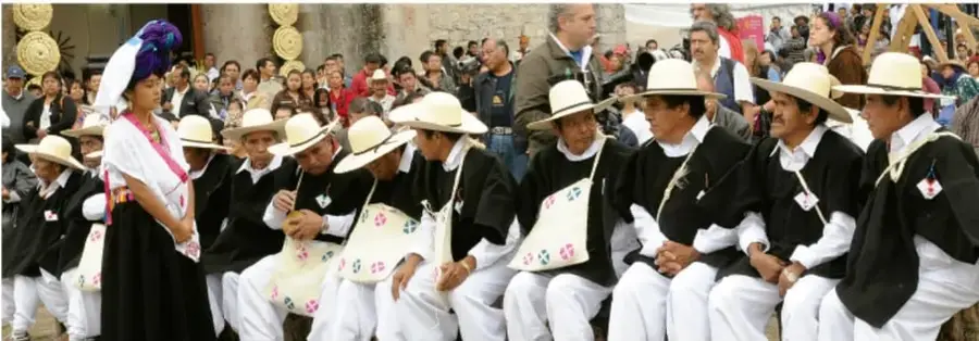 Fotografía de personas con vestimenta tradicional sentadas en fila durante una actividad comunitaria, fotografía de Salatiel Barragán Santos, Veracruz