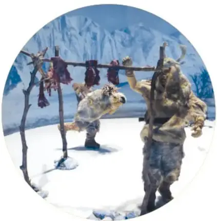 Maqueta de una mujer de la prehistoria, con cabello largo y ropa de pieles, que recolecta plantas silvestres y las guarda en una canasta tejida.