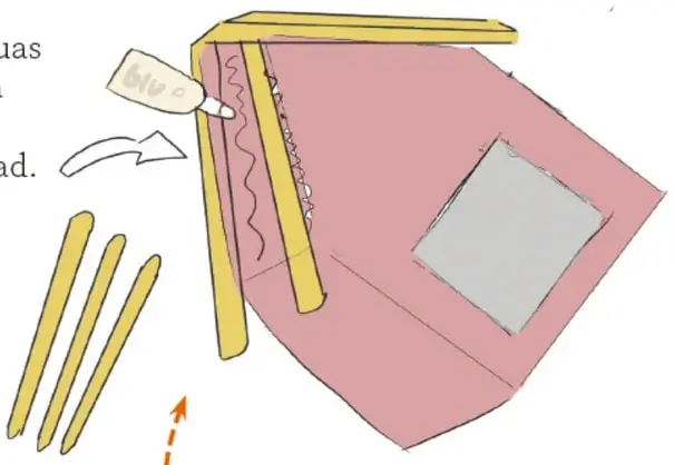 Manos aplicando pegamento a un abatelenguas y colocándolo sobre el techo de una casita de cartón rosa con ventan a cuadrada; abajo se ven tres abatelenguas sueltos.