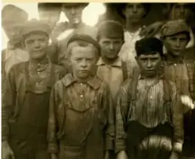 Fotografía en blanco y negro de niños trabajadores en una fábrica durante la Revolución industrial.