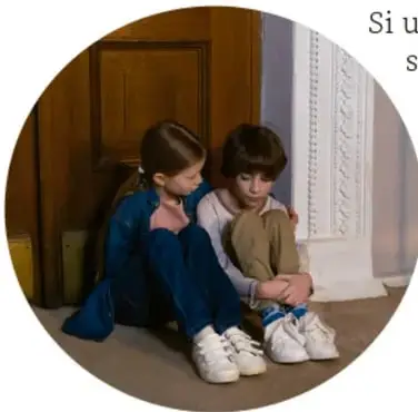 Fotografía circular de dos niños sentados en el piso junto a una puerta, con gesto triste; una niña se inclina hacia ellos para consolarlos: ejemplo de empatía ante la pérdida de un juguete.