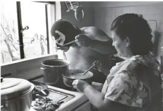 Fotografía en blanco y negro de El Brazo de Plata cocinando junto a su madre, doña Ana Nieves de Alvarado, en una cocina.