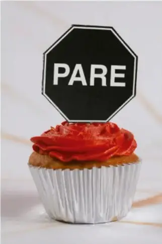 Pastelillo con betún rojo y un señalamiento de PARE encima, como símbolo de advertencia.