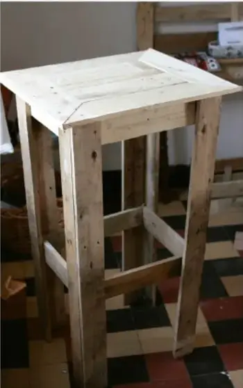 Fotografía de un mueble (mesa de noche) construido con materiales de reutilización (madera) como ejemplo de alternativa de solución.