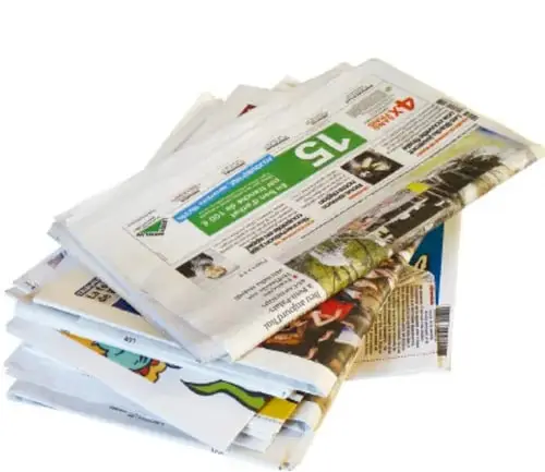 Pila de periódicos y revistas de varios idiomas sobre una mesa.