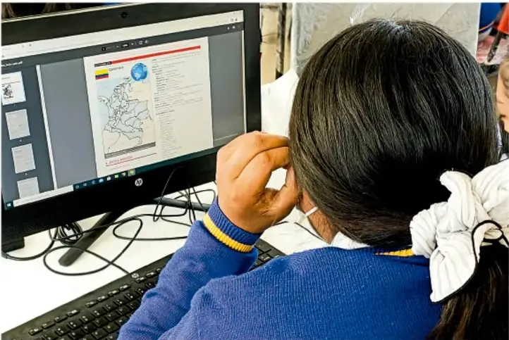 Fotografía de una estudiante de espaldas frente a un monitor de computadora, que muestra un mapa en pantalla; crédito: Luis Eduardo García Medel, Tlaxcala.