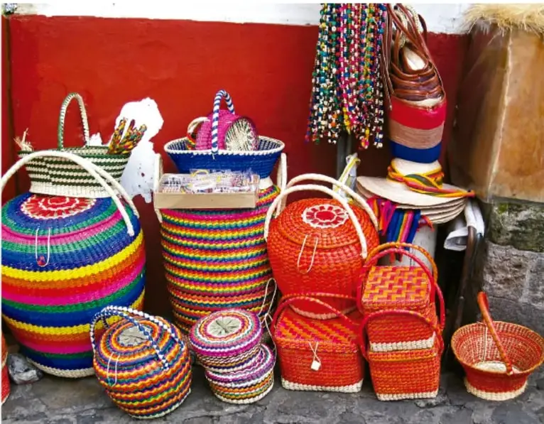 Fotografía de artesanías tejidas (canastas, sombreros, textiles) de colores, ilustrando el objeto artesanal del proyecto.