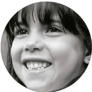 Fotografía en blanco y negro de una niña sonriente, como imagen de participación estudiantil.