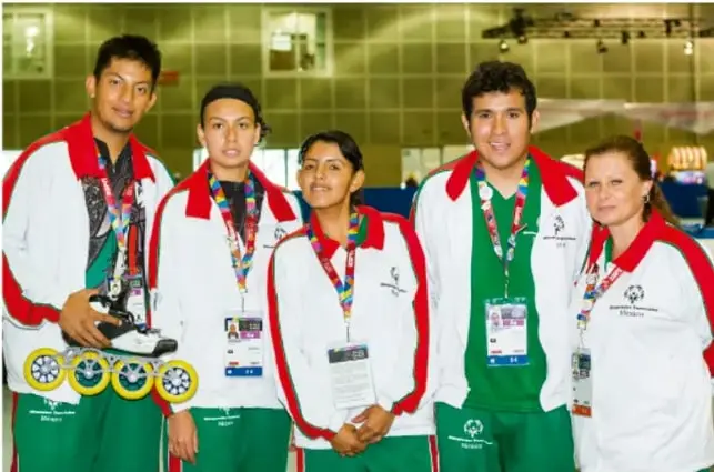 Fotografía de cinco jóvenes deportistas con uniforme blanco, verde y rojo, con medallas y una tabla de skate, representando la diversidad de expresiones juveniles.