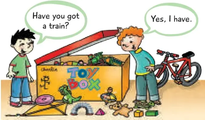 Niño junto a una caja de juguetes amarilla con la palabra 'Toy Box'; otro niño saca un tren rojo. Al fondo, una bicicleta roja.