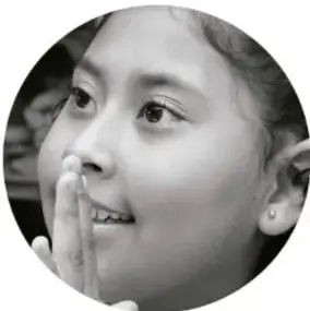 Fotografía en blanco y negro de una niña pensativa con la mano en el mentón.